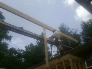 Carpenter setting a ridge beam over a new addition frame — Ice Dam Removal by Roofing Brothers in Nodaway