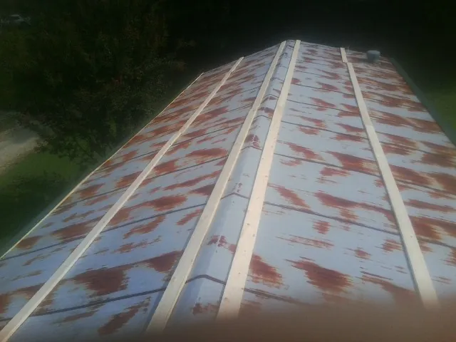 Rusted metal roof panels with new wood purlins before replacement — Storm Damage Roof Repair in Nodaway by Roofing Brothers