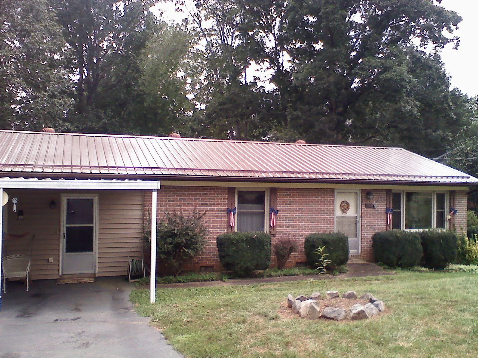Bronze metal roof and carport on a brick ranch home — Roof Repair work by our crew in Nodaway