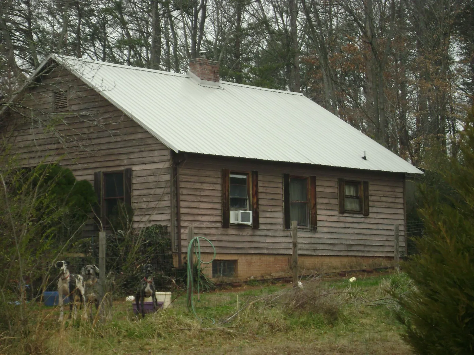 White metal roof on an old wood sided farmhouse, from a Metal Roof Installation job in Nodaway